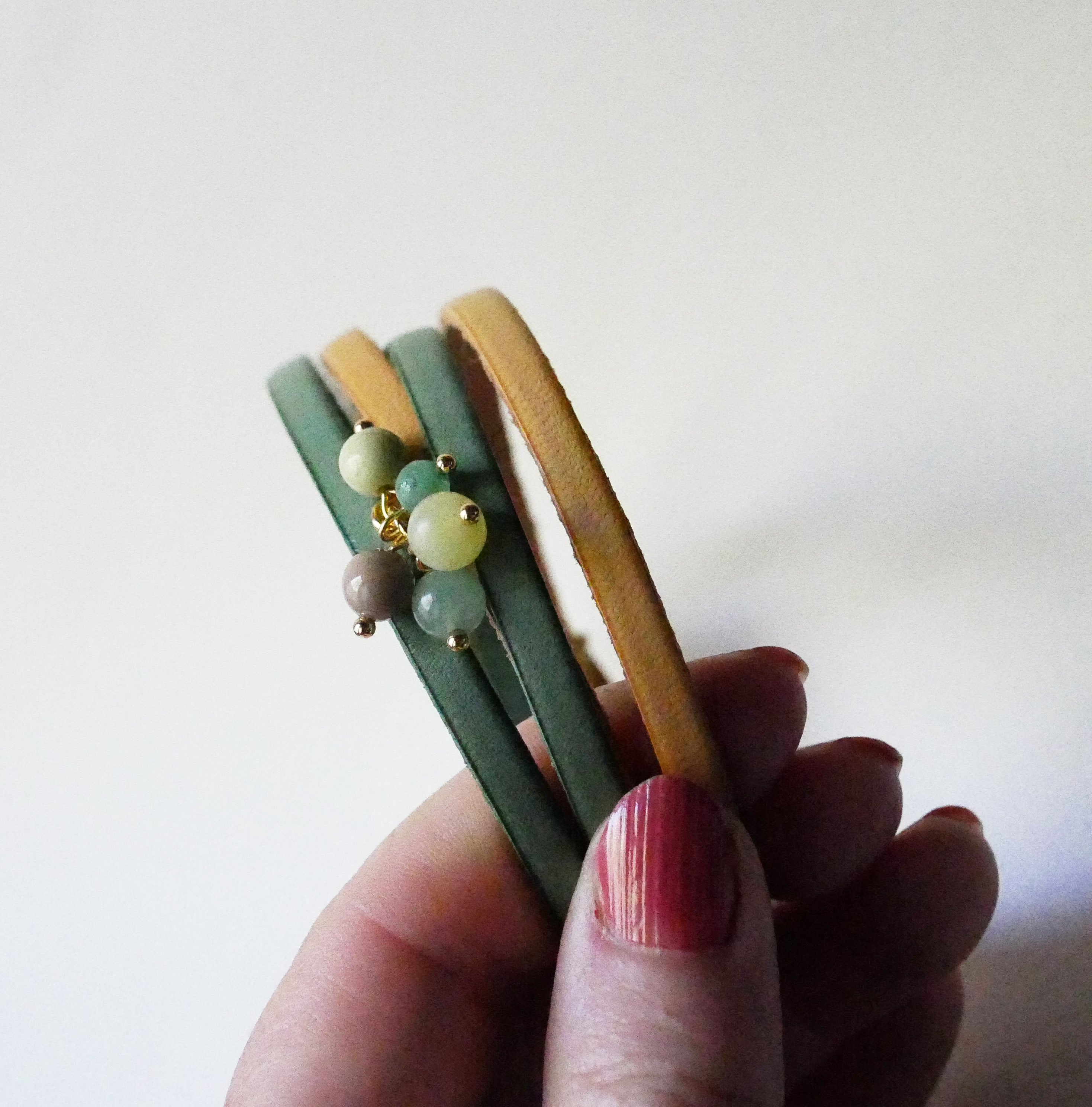 Double leather bracelet decorated with soft green pearls and gold clasp