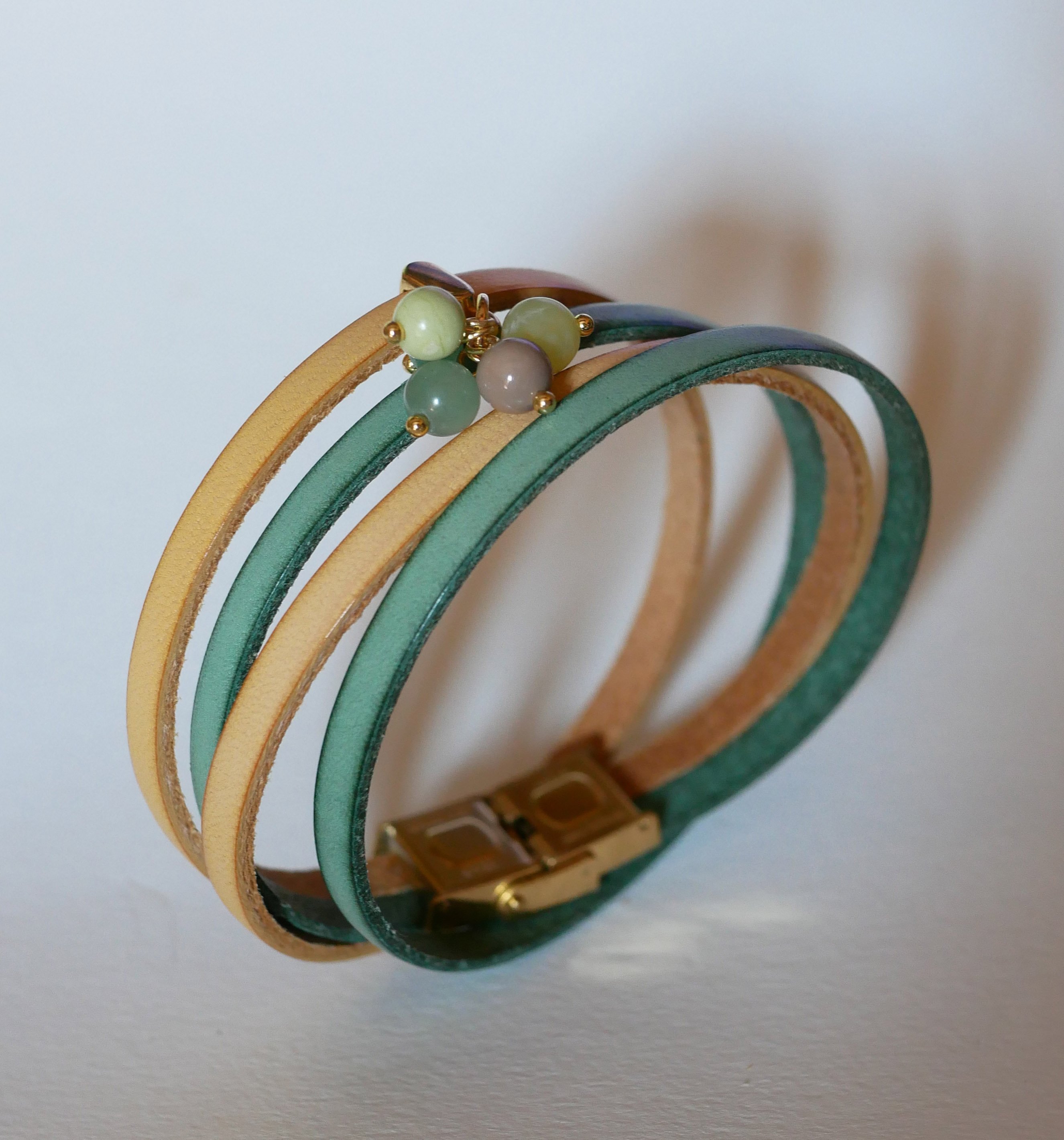 Double leather bracelet decorated with soft green pearls and gold clasp