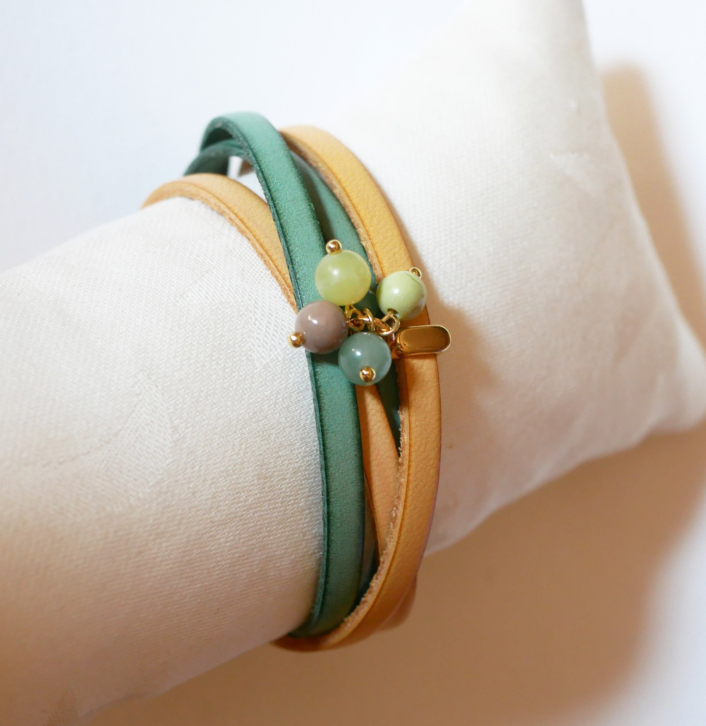 Double leather bracelet decorated with soft green pearls and gold clasp