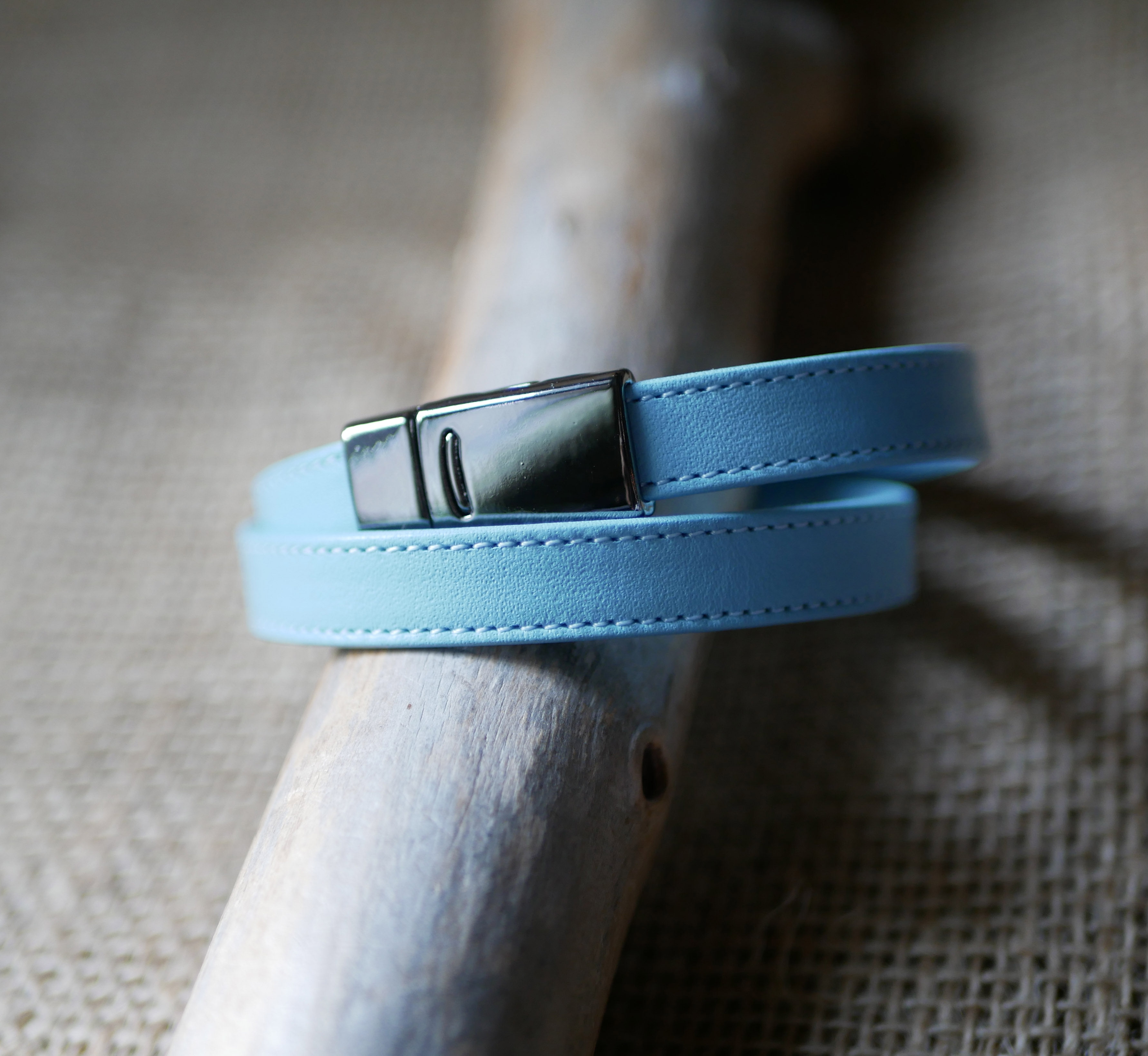 Double-turned leather strap with sky-blue or beige stitching and magnetic clasp 