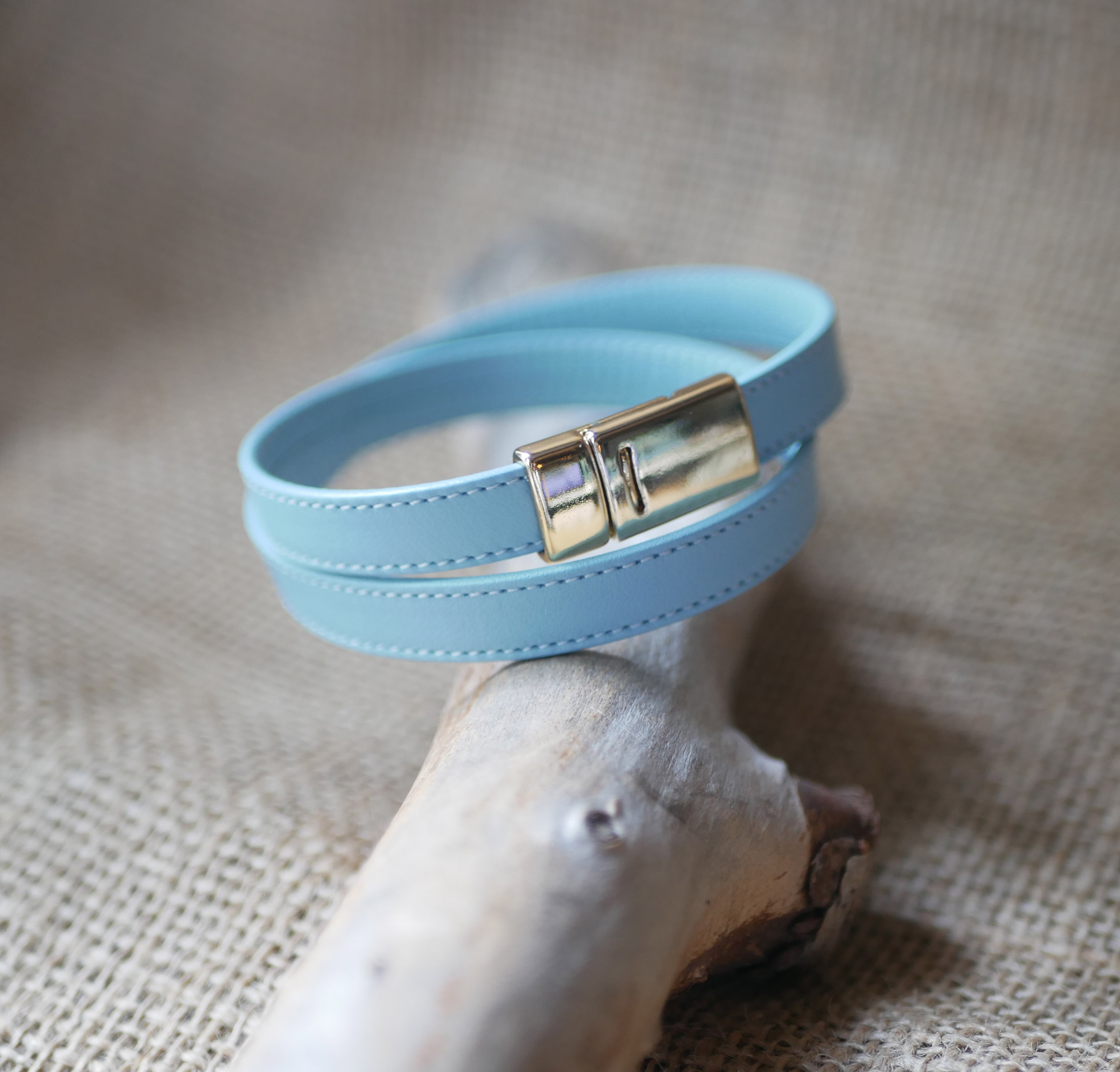 Double-turned leather strap with sky-blue or beige stitching and magnetic clasp 