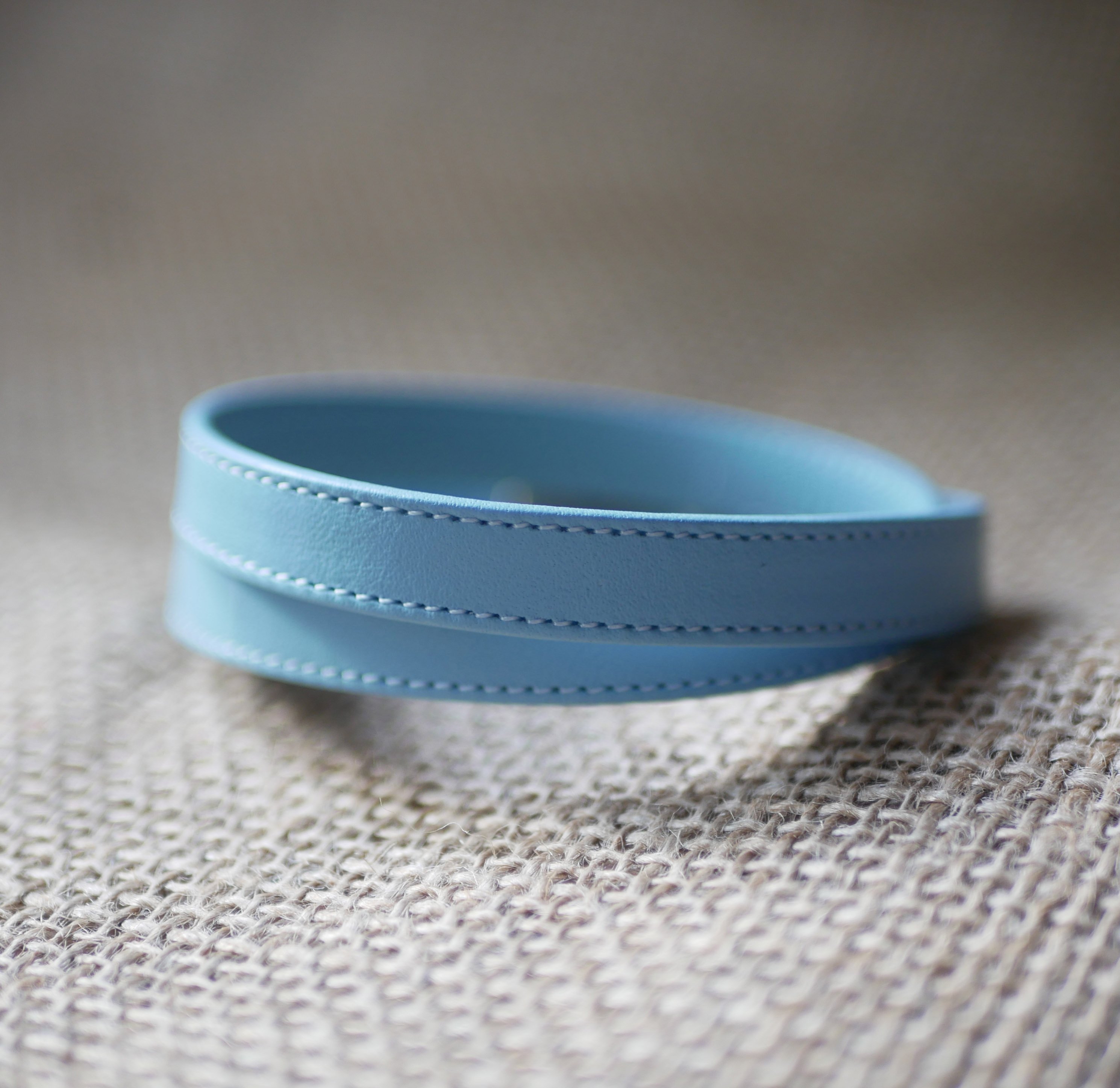 Double-turned leather strap with sky-blue or beige stitching and magnetic clasp 