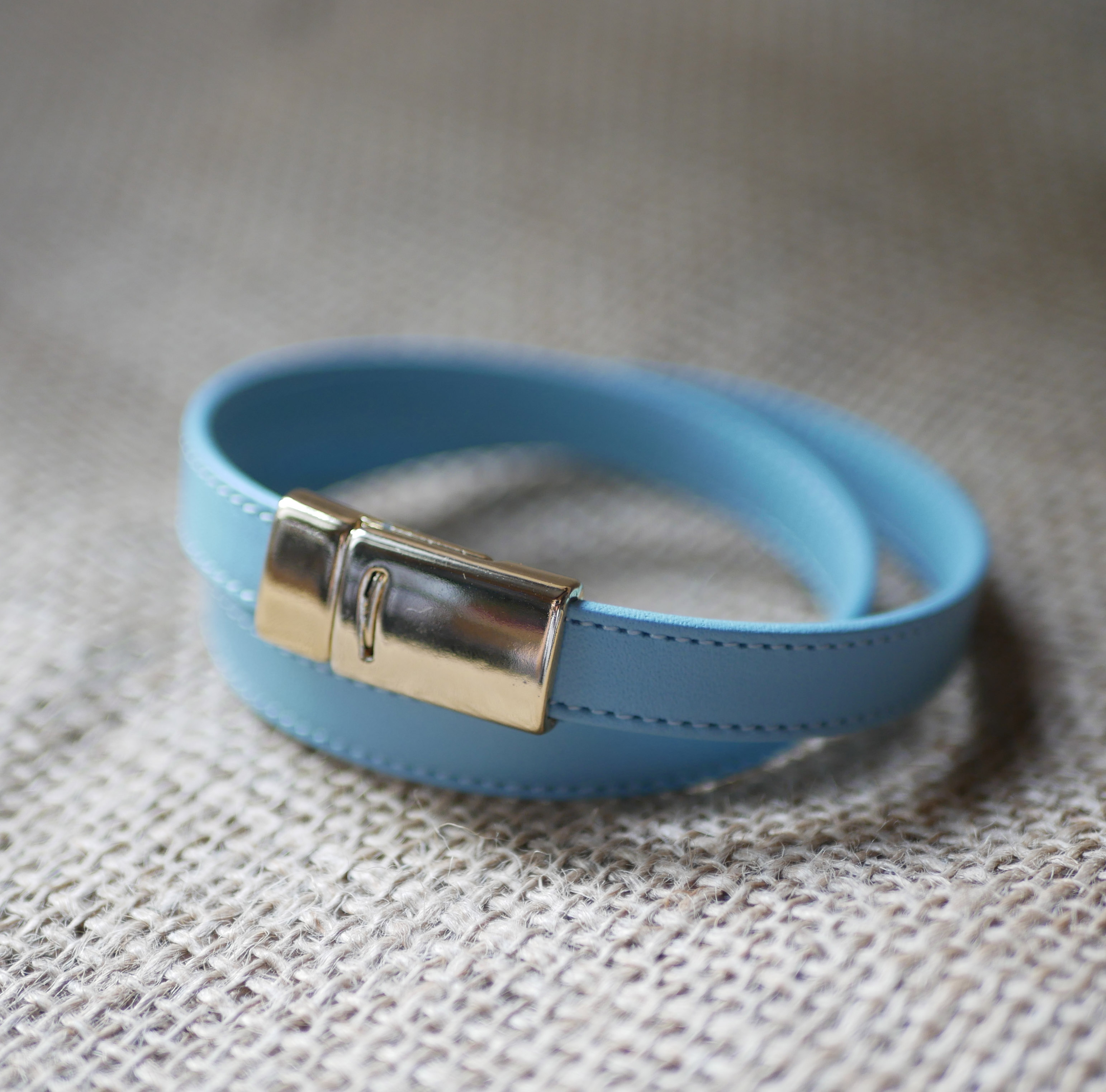 Double-turned leather strap with sky-blue or beige stitching and magnetic clasp 