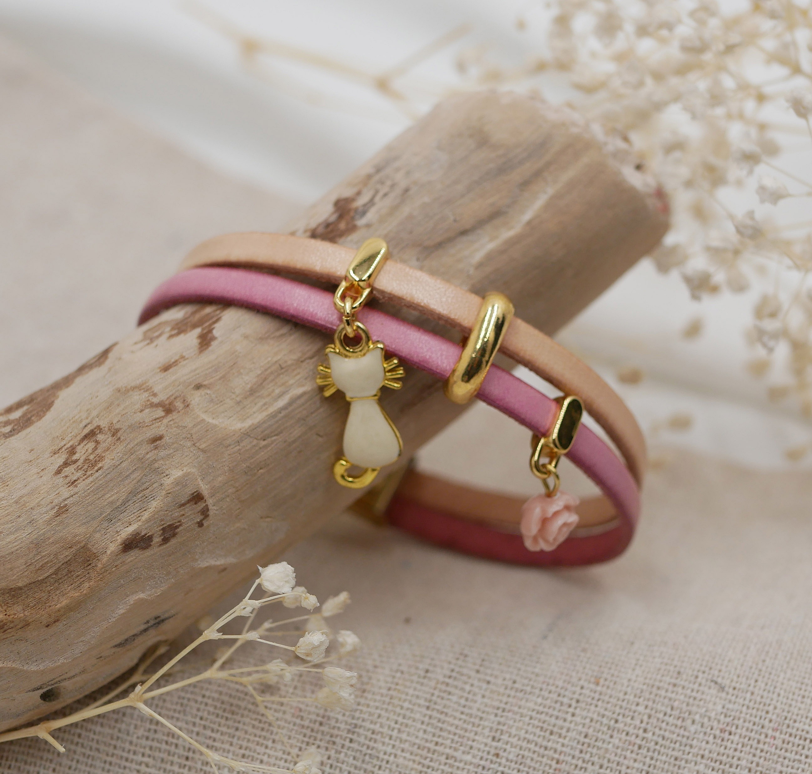 Bracelet duo en cuir avec breloques chat et rose dorées.