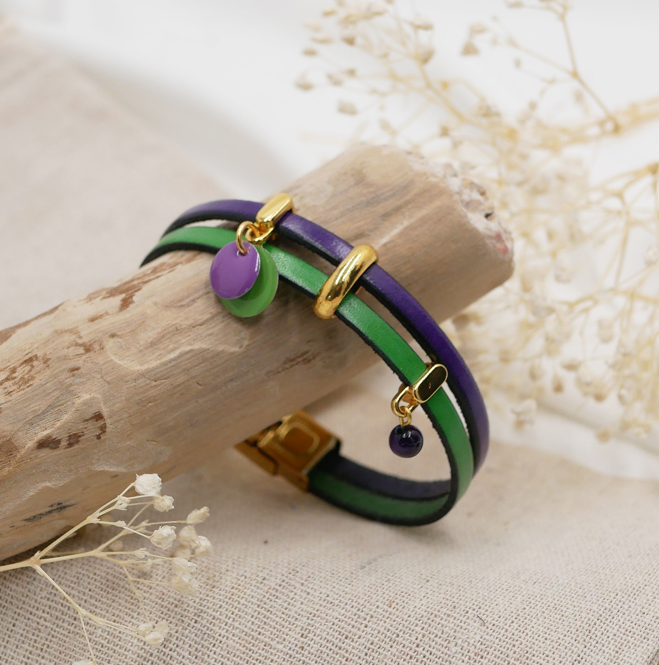 Bracelet duo en cuir violet et vert avec breloques dorées.
