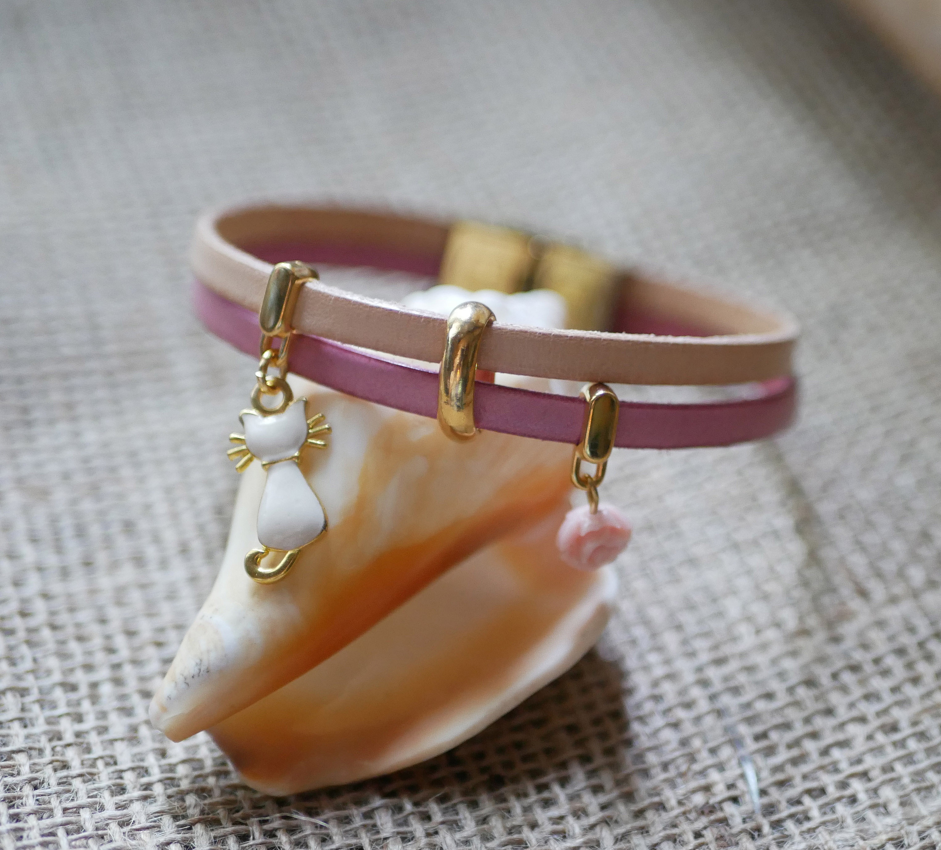 Bracelet duo en cuir avec breloques chat et rose dorées.