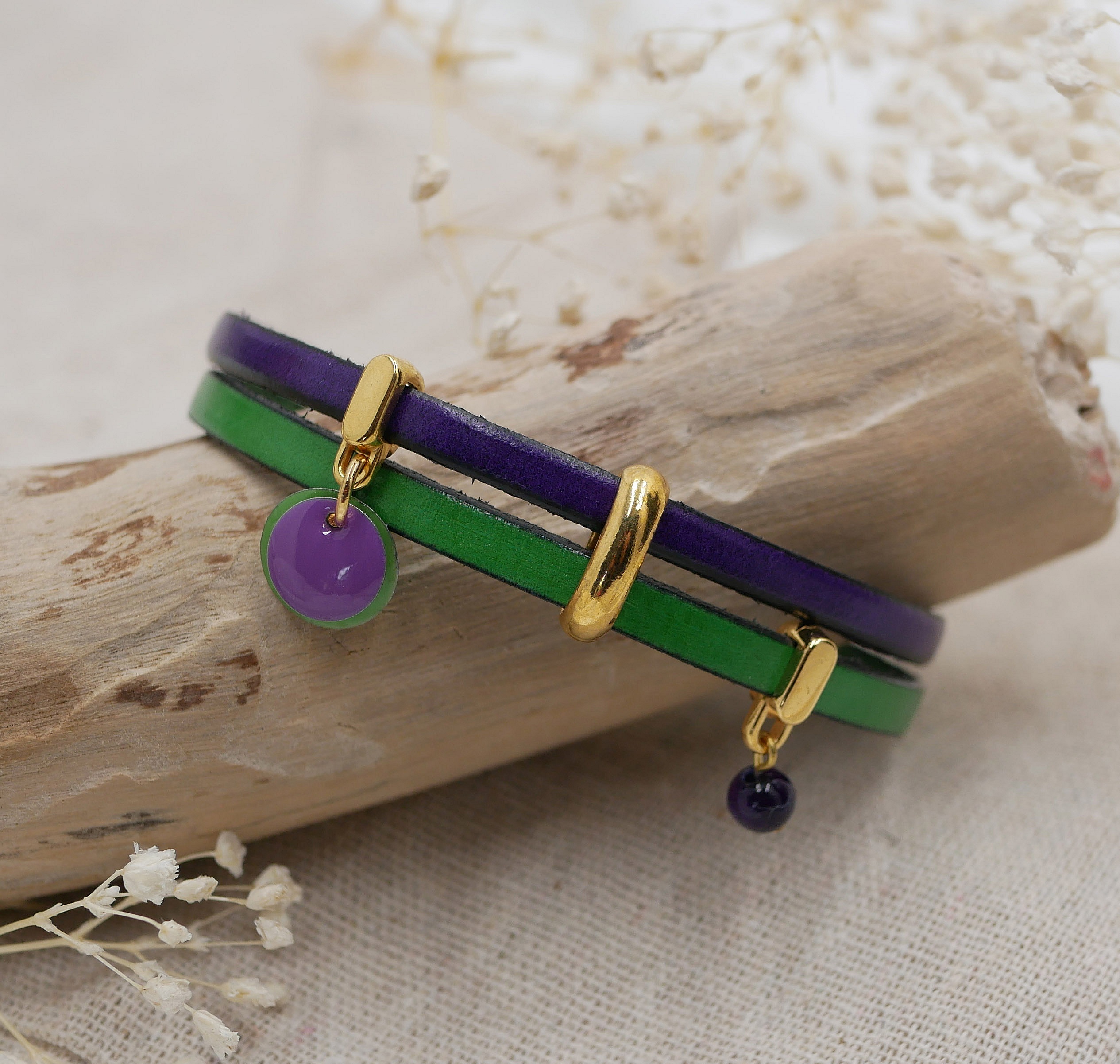 Bracelet duo en cuir violet et vert avec breloques dorées.