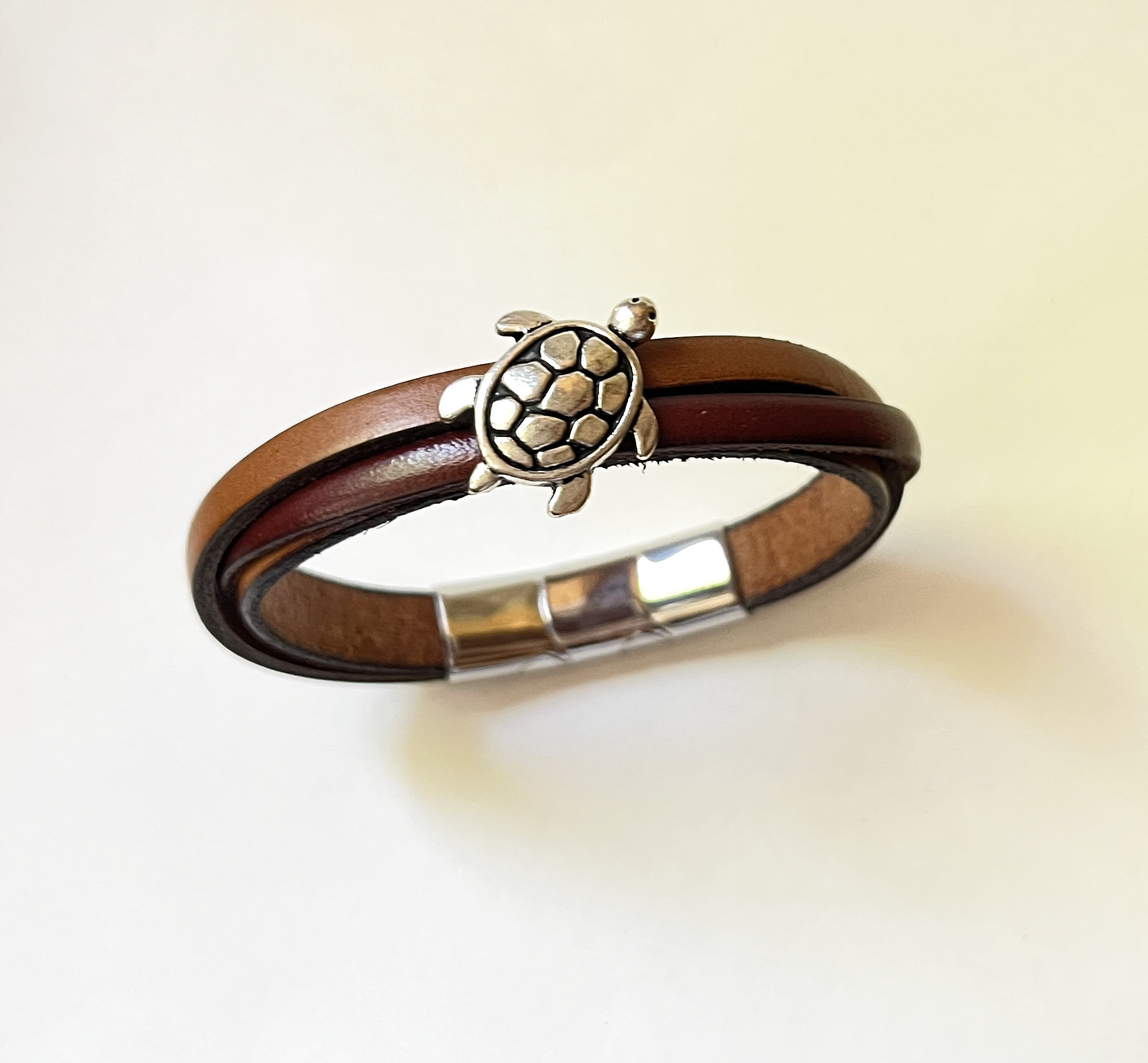 Bracelet manchette homme en cuir bicolore croisé avec fermoir.