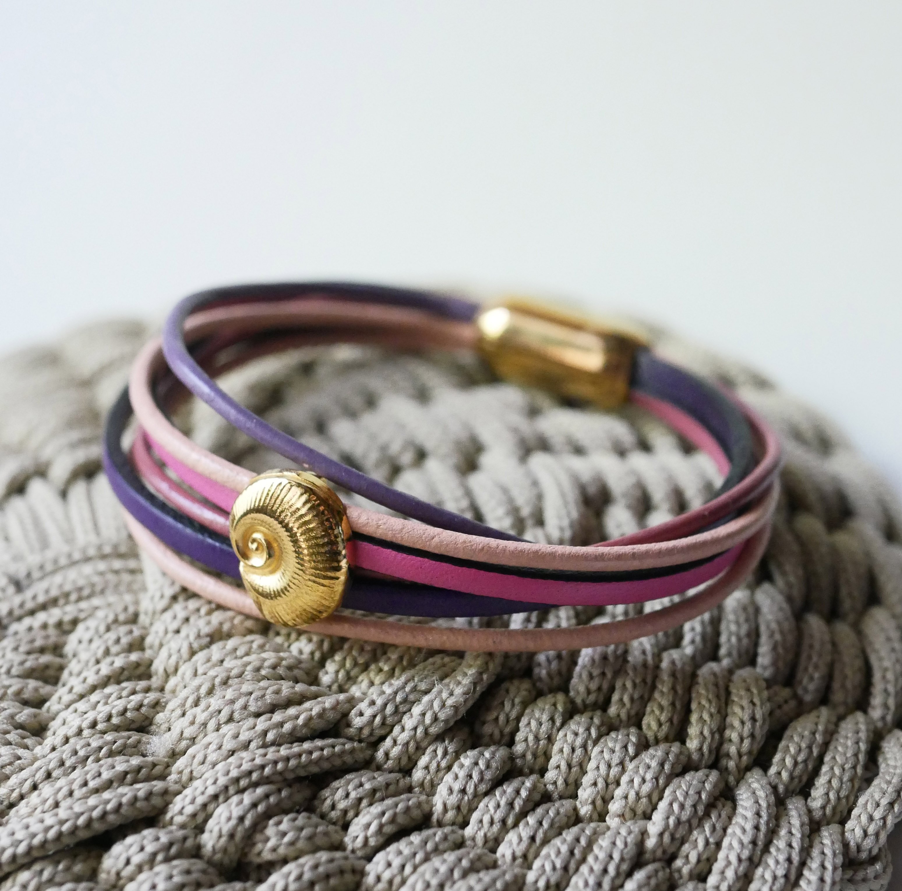 Multi-link bracelet in peach and mauve leathers with gold shell decoration