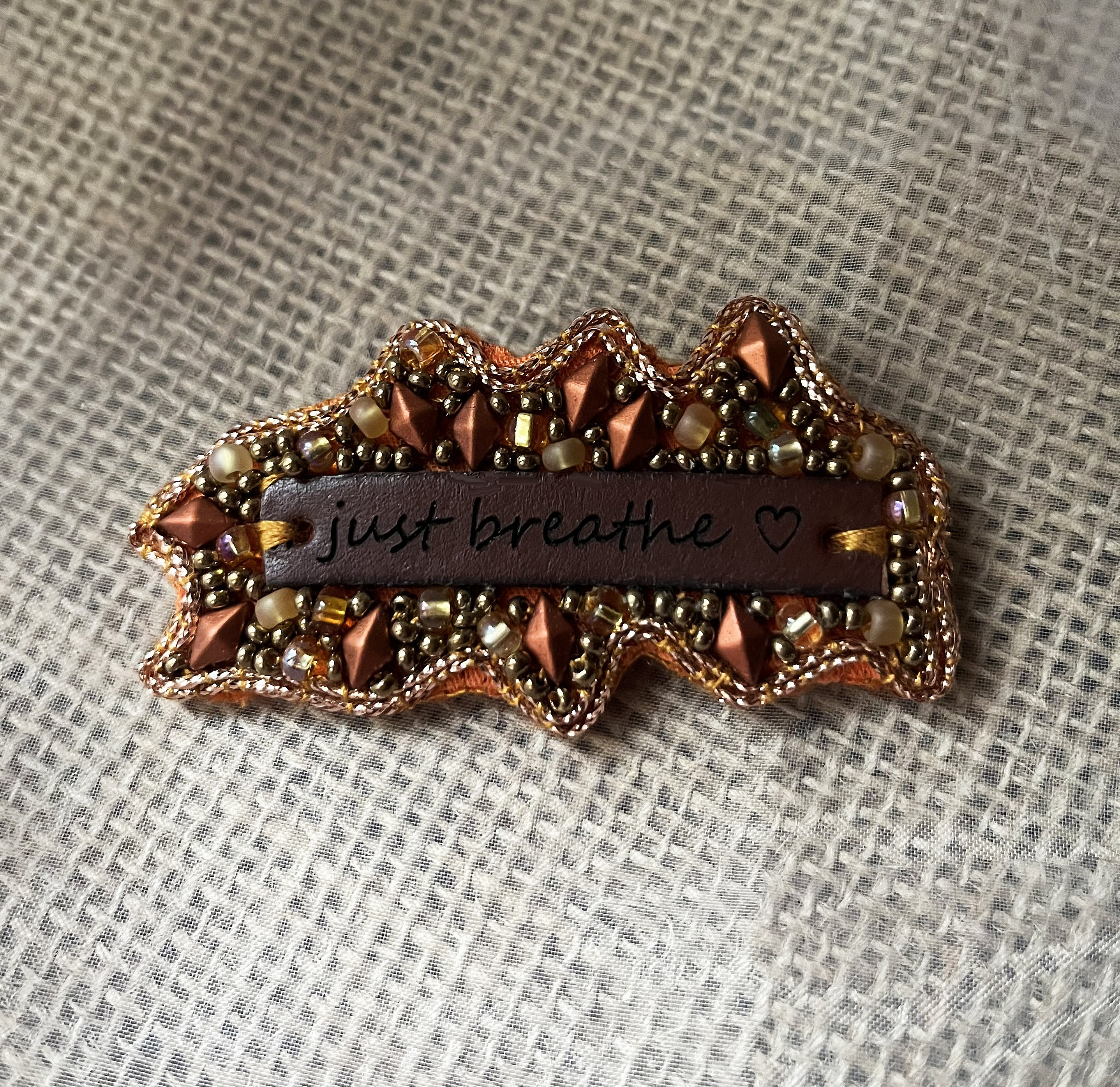 Broche en perles cuivr&eacute;es &agrave; message en cuir grav&eacute; "Just breathe"