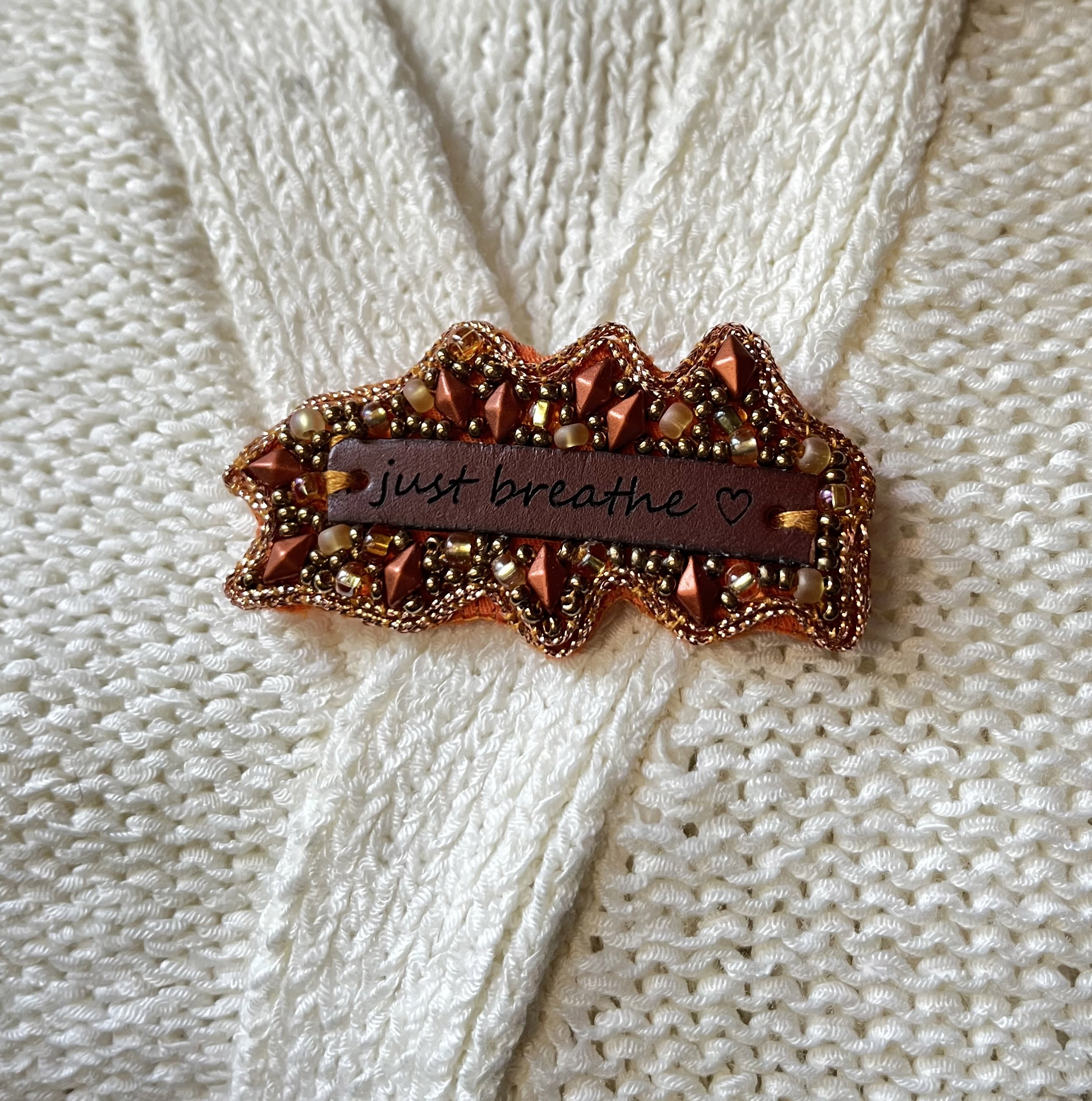 Broche en perles cuivrées à message en cuir gravé "Just breathe"