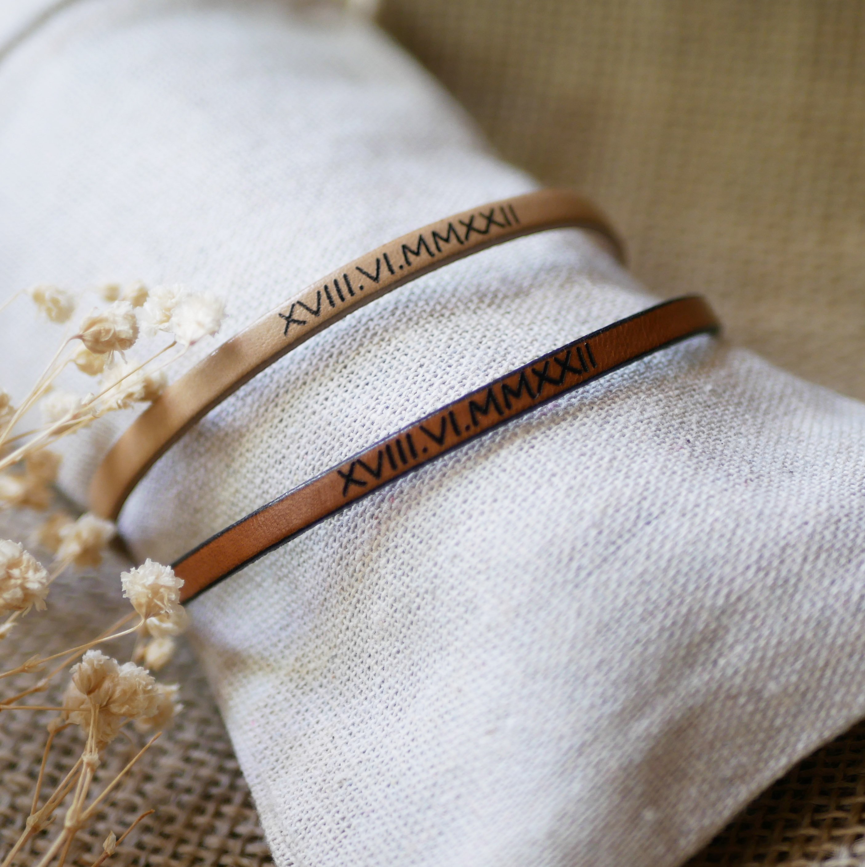 Gift bracelets for couples in leather, both personalized with the same engraving 
