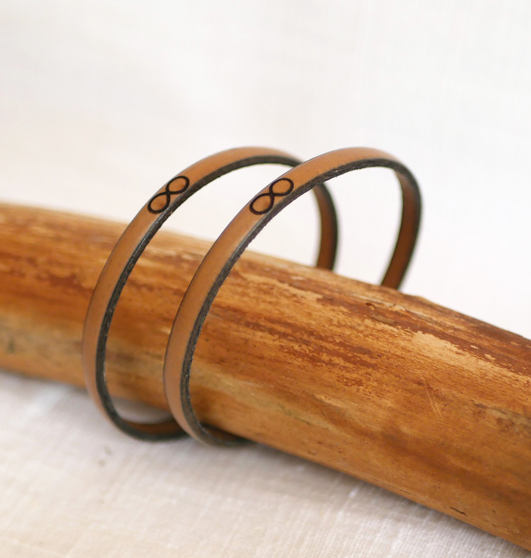 Gift bracelets for couples in leather, both personalized with the same engraving 