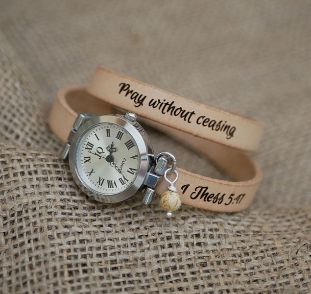 Montre bracelet en cuir personnalisée avec inscription religieuse gravée.