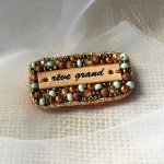 Broche en perles dorées à message en cuir gravé "rêve grand"